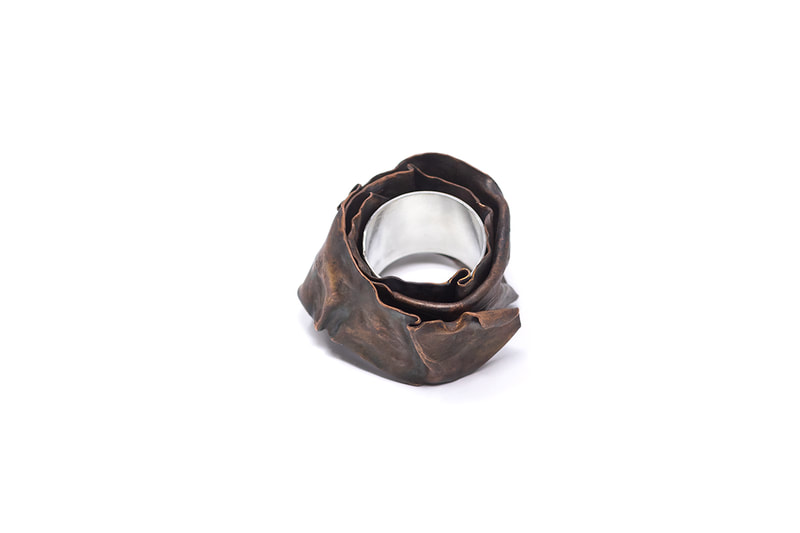 Chunky silver and copper ring in patinated brown color viewed from the side