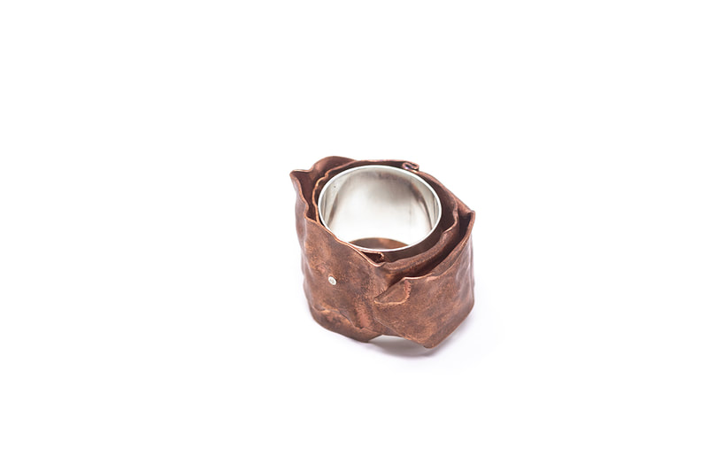 Chunky silver and copper ring in natural copper color on white background