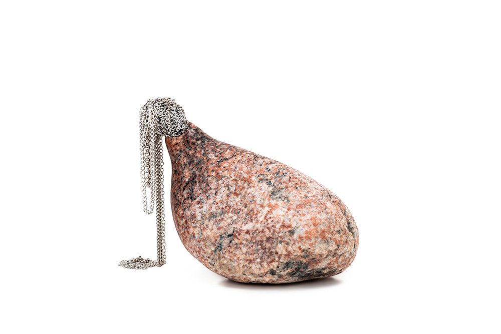 An organ-like granite sculpture with jewellery pouring out of it called Sanguine Memory I by Hanna Ryynänen