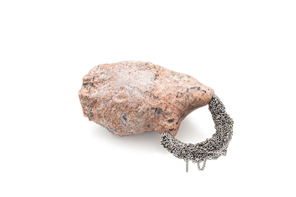 An organ-like granite sculpture with jewellery pouring out of it called Sanguine Memory II by Hanna Ryynänen